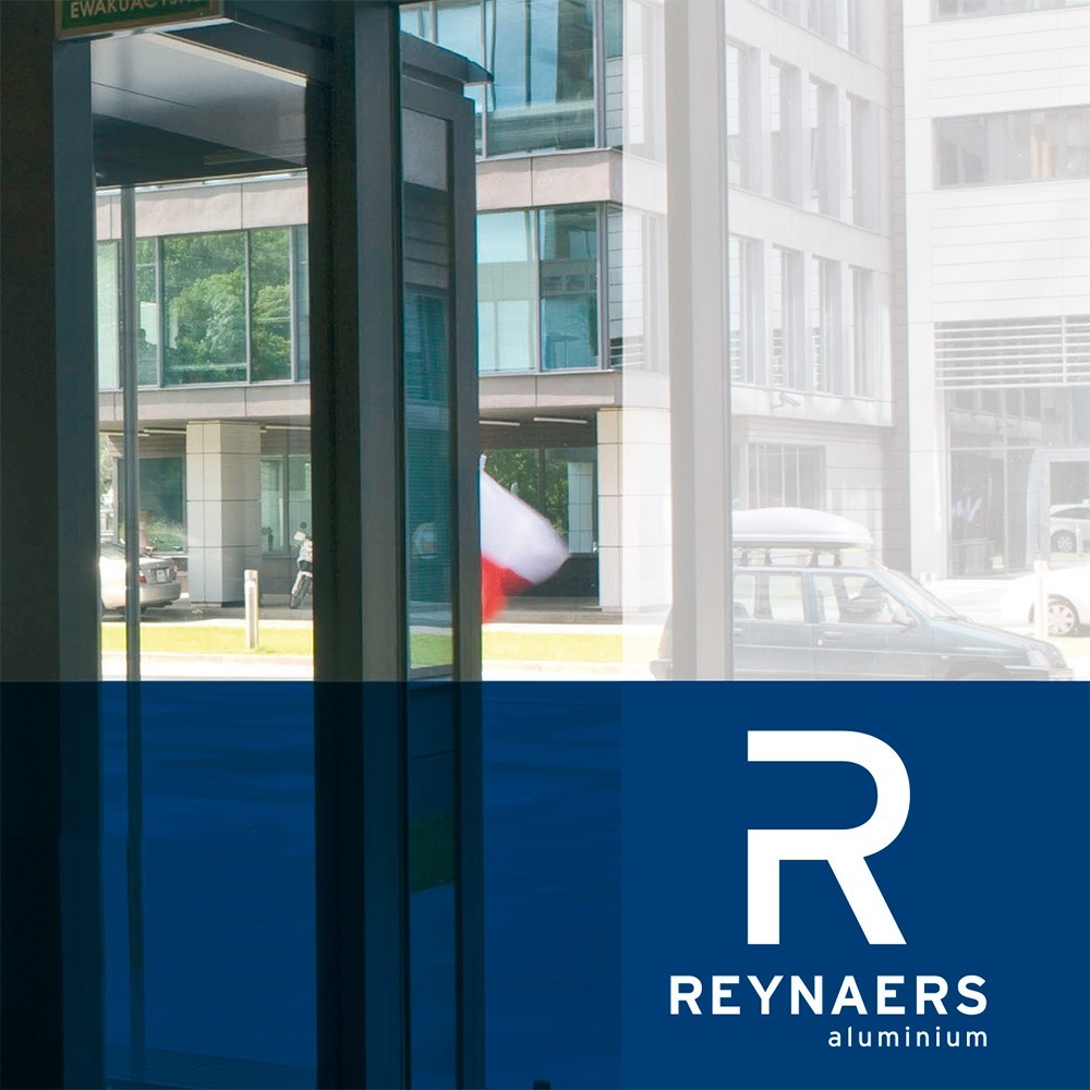 logo Reynaers, menuiserie aluminium, rue avec voitures